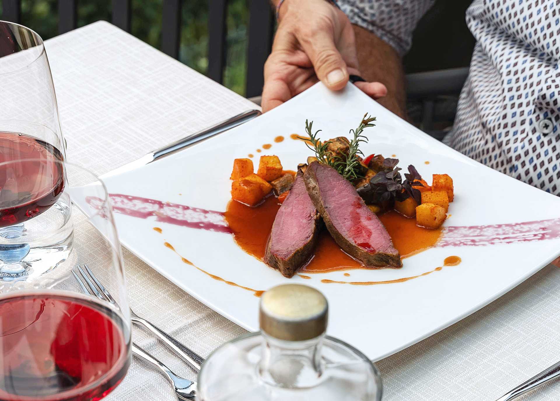Tender pink-cooked meat dishes are part of the menu, alongside fish and vegetarian options The main course, veal loin with potatoes and a delicate sauce, is served.